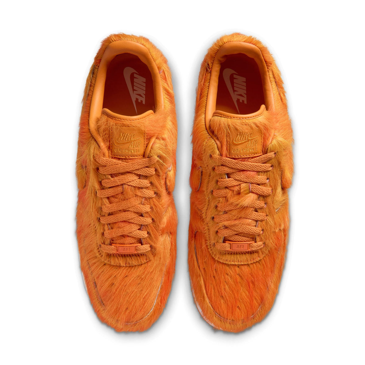 Nike Men's Air Force 1 sneakers in orange pony hair with white soles, showcasing stylish men's footwear.