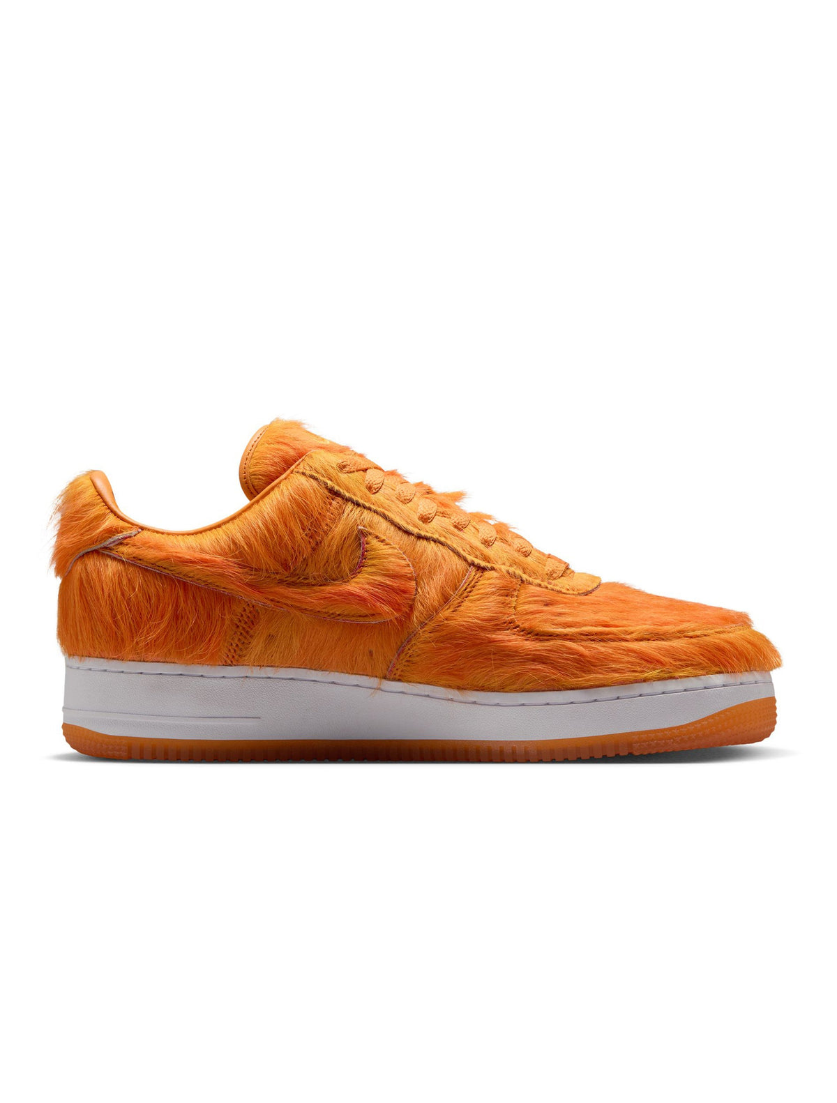 Nike men's Air Force 1 sneakers in orange pony hair with white soles, showcasing a stylish and bold footwear design.