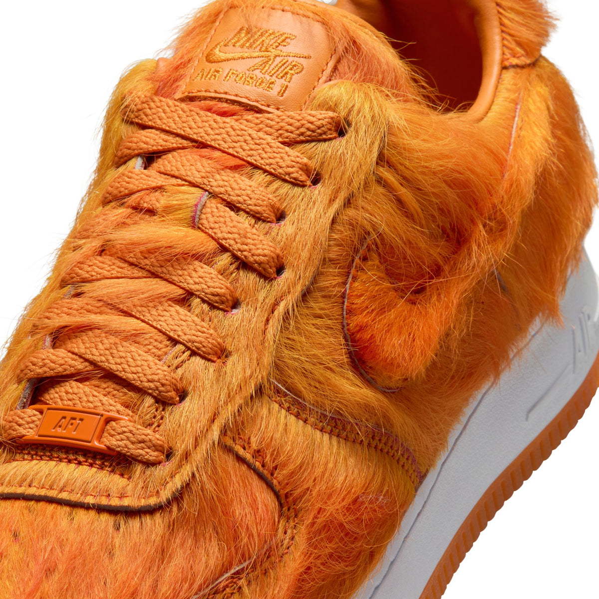 Nike Men's Air Force 1 sneakers in orange pony hair, showcasing stylish men's footwear with textured leather details.