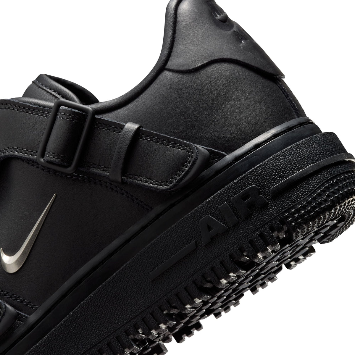 Black Nike Air Force 1 Luxe men's footwear with sleek design and premium details, displayed in a natural pose.