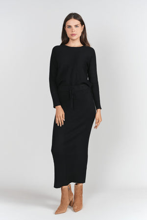 Black ribbed sweater skirt by Adina Las Vegas, showcasing a fitted high-waist design with soft knit fabric.