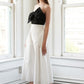Black Flying Tomato Blissful Breeze woven midi dress displayed on a hanger with pleated fabric and adjustable straps.