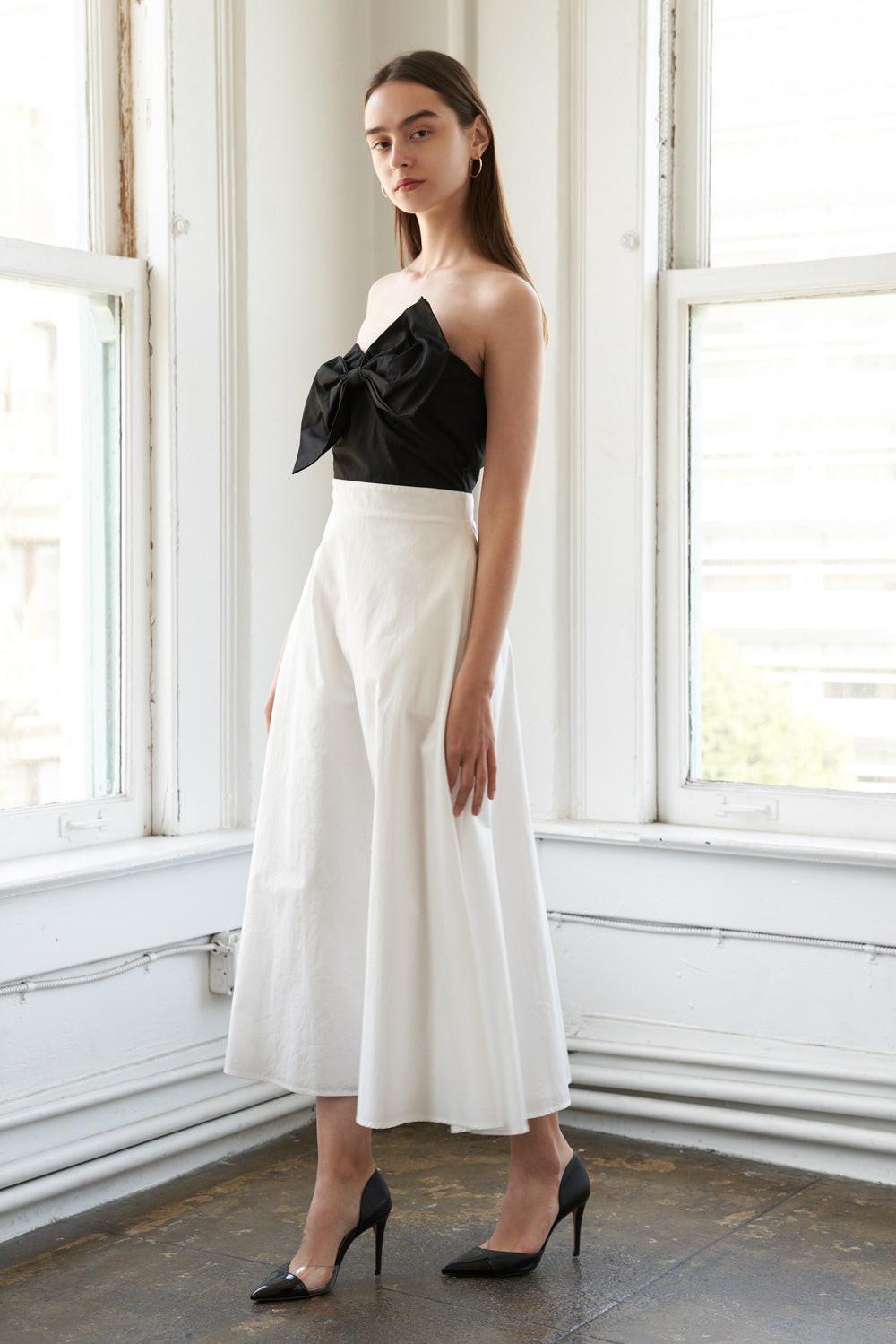 Black Flying Tomato Blissful Breeze woven midi dress displayed on a hanger with pleated fabric and adjustable straps.