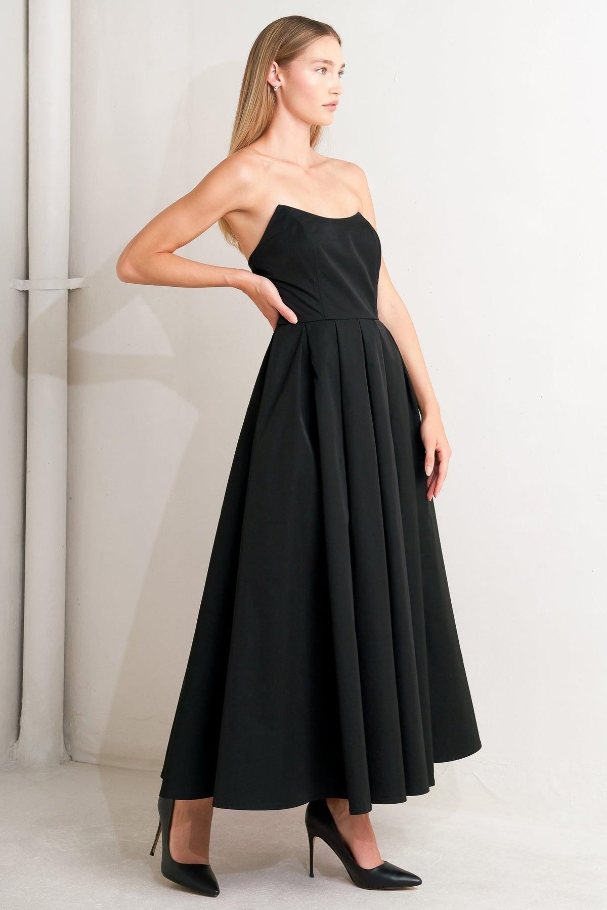 Flying Tomato Gala Noir woven midi dress in black, with a fitted waist and flowing skirt, displayed on a dress form.