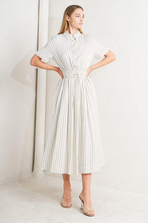 Flying Tomato Sunday Stripe Woven Midi Dress in ivory and blue with a striped pattern, shown hanging on a display.
