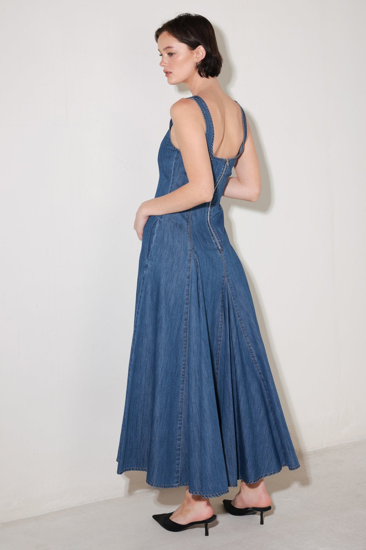 Medium indigo Flying Tomato Sway Denim Midi Dress with a fitted bodice and flowing skirt, displayed on a hanger.