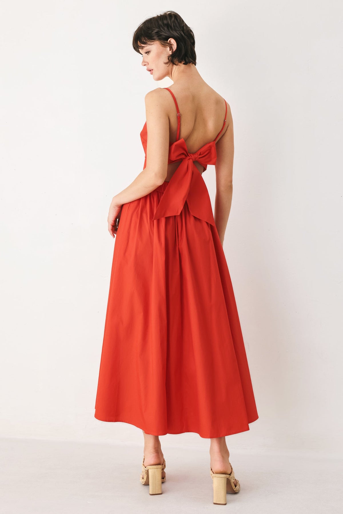 Flying Tomato Riviera Nights woven midi dress in coral red featuring a flowing, patterned fabric with a fitted waist and sleeveless design.