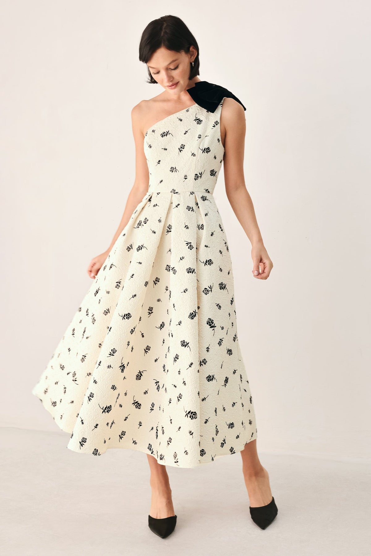 Cream and black one-shoulder bow midi dress by Flying Tomato, featuring elegant draping and a fitted silhouette.