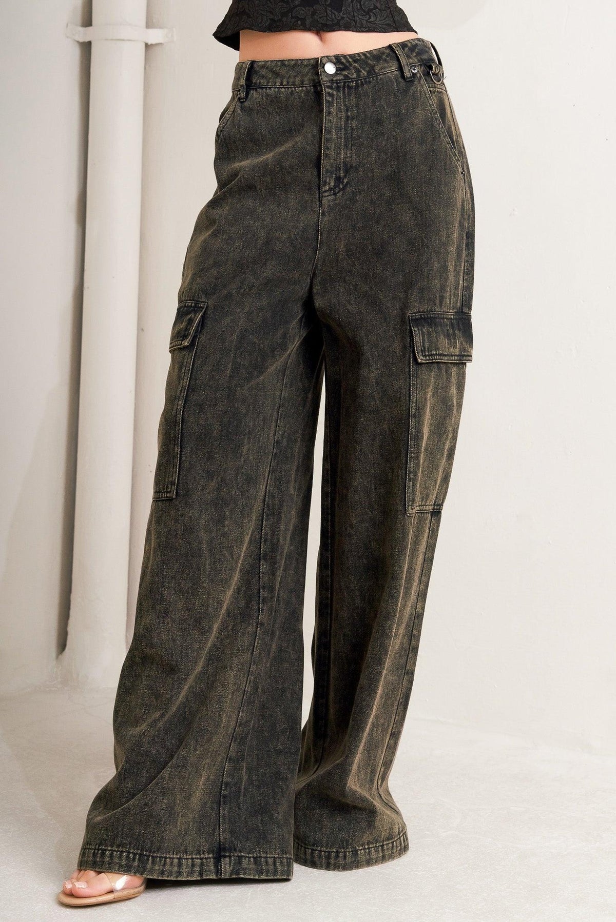 Black Flying Tomato Can't Blame Me Garg Denim Pants hanging on a display with front view and detailed stitching.
