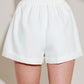 White Summer Icon Mode woven shorts by Flying Tomato, featuring a relaxed fit and casual style, shown on a model.