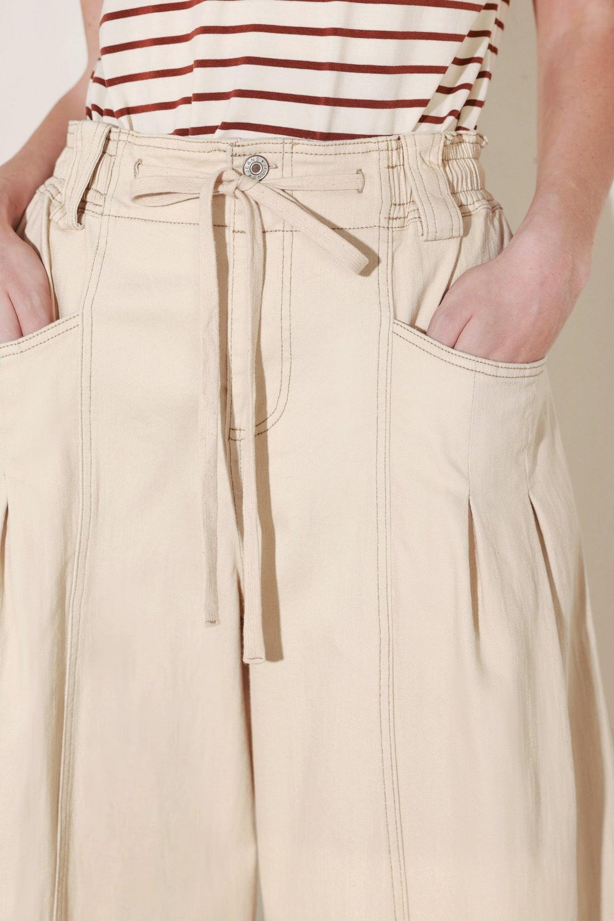 Light beige Flying Tomato Daylight Groove woven pants with a relaxed fit, shown on a model.