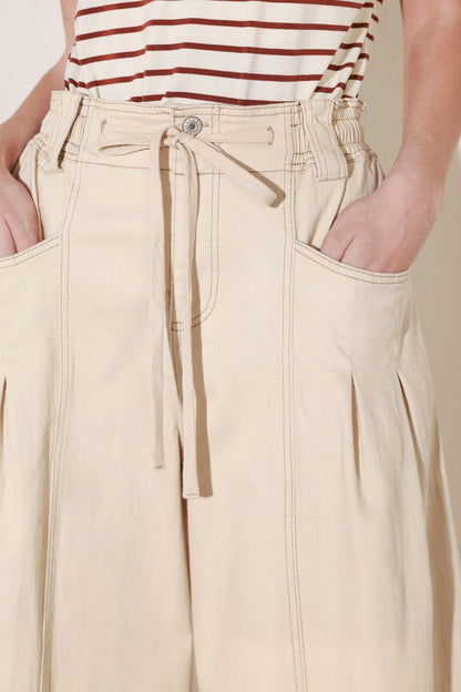 Light beige Flying Tomato Daylight Groove woven pants with a relaxed fit, shown on a model.