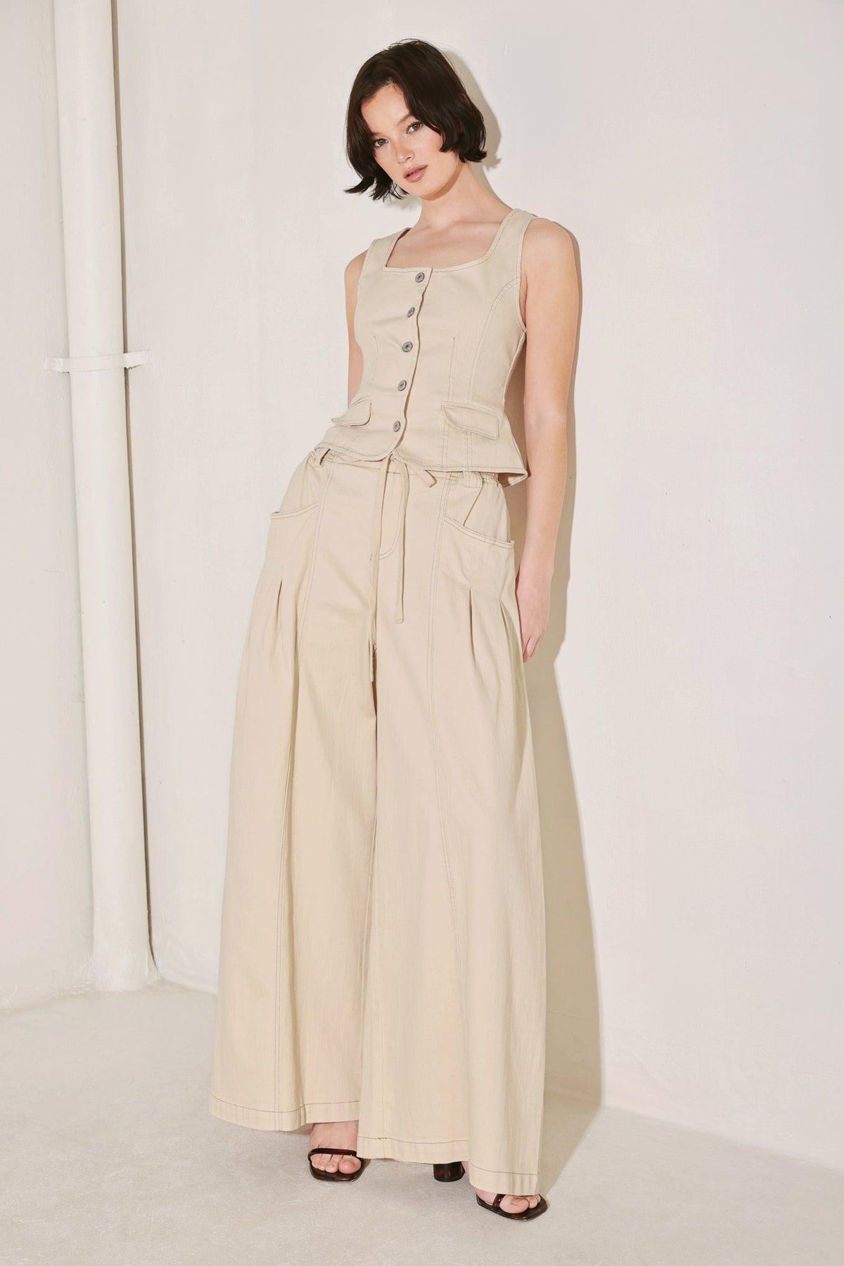 Light beige Daylight Groove woven pants by Flying Tomato, showcasing relaxed fit and textured fabric detail.