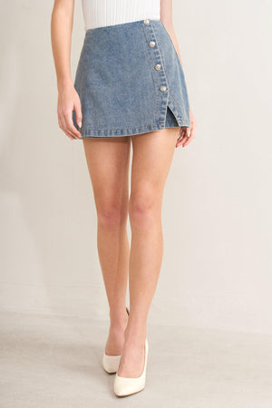 Light indigo Flying Tomato Santa Monica denim skort with front pockets and button closure, styled with casual top and accessories.