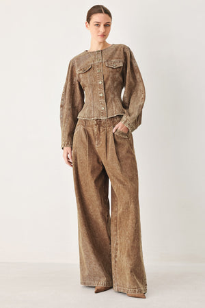 Vintage brown denim pants by Flying Tomato, shown laid flat with details of the classic denim texture and stitching.