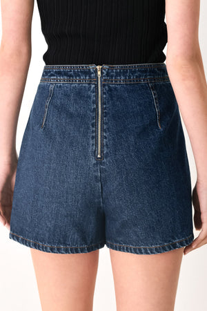 Flying Tomato Run the City denim skort in indigo, featuring a stylish front and back view with pockets and a button closure.