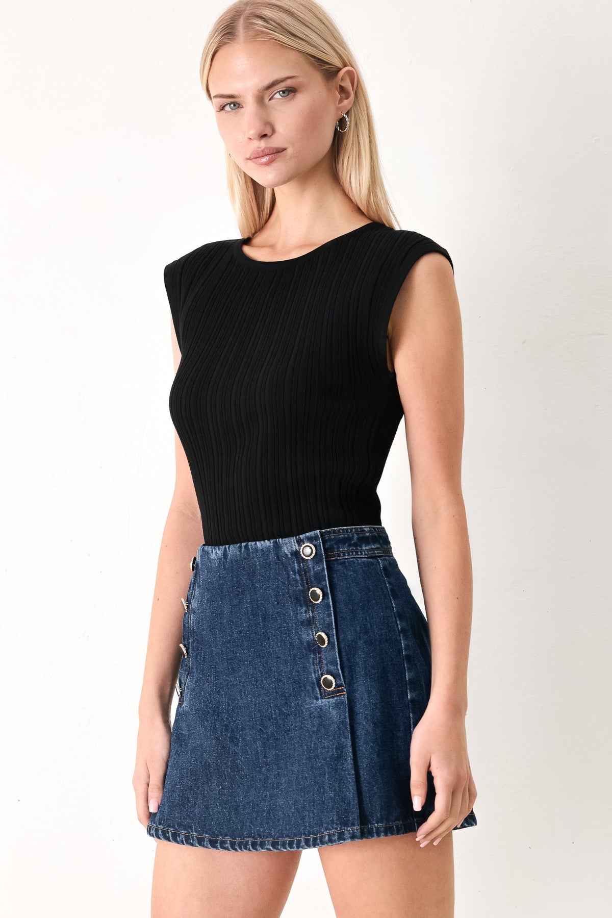 Flying Tomato denim skort in indigo with front pockets and a button closure, styled for casual city wear.