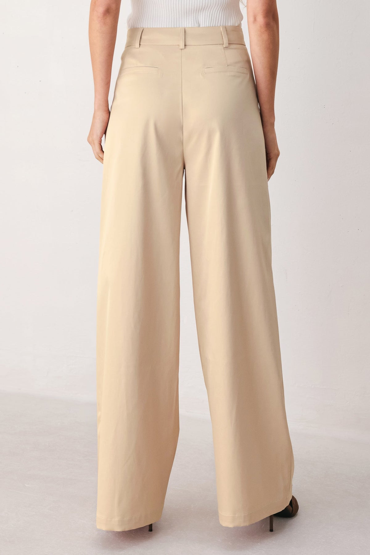 Flying Tomato parchment relaxed-fit woven pants in champagne color, shown folded with soft fabric texture and casual style.