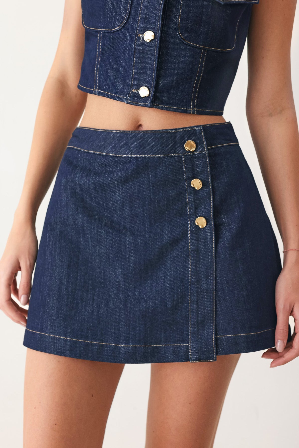 Flying Tomato iconic indigo denim skort, casual summerwear with a front button and pocket details, laid flat on a white background.