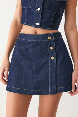 Flying Tomato iconic indigo denim skort, casual summerwear with a front button and pocket details, laid flat on a white background.