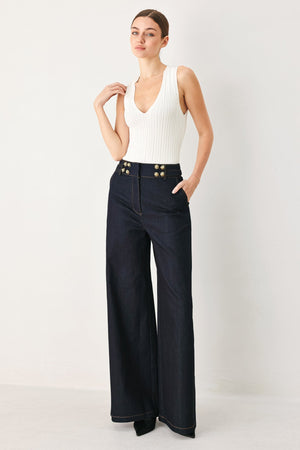 Dark indigo denim pants by Flying Tomato, shown on a model, featuring classic five-pocket design and straight-leg fit.
