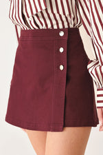 Flying Tomato Merlot Ridge woven skort in burgundy, featuring a stylish design with a comfortable fit and detailed fabric texture.