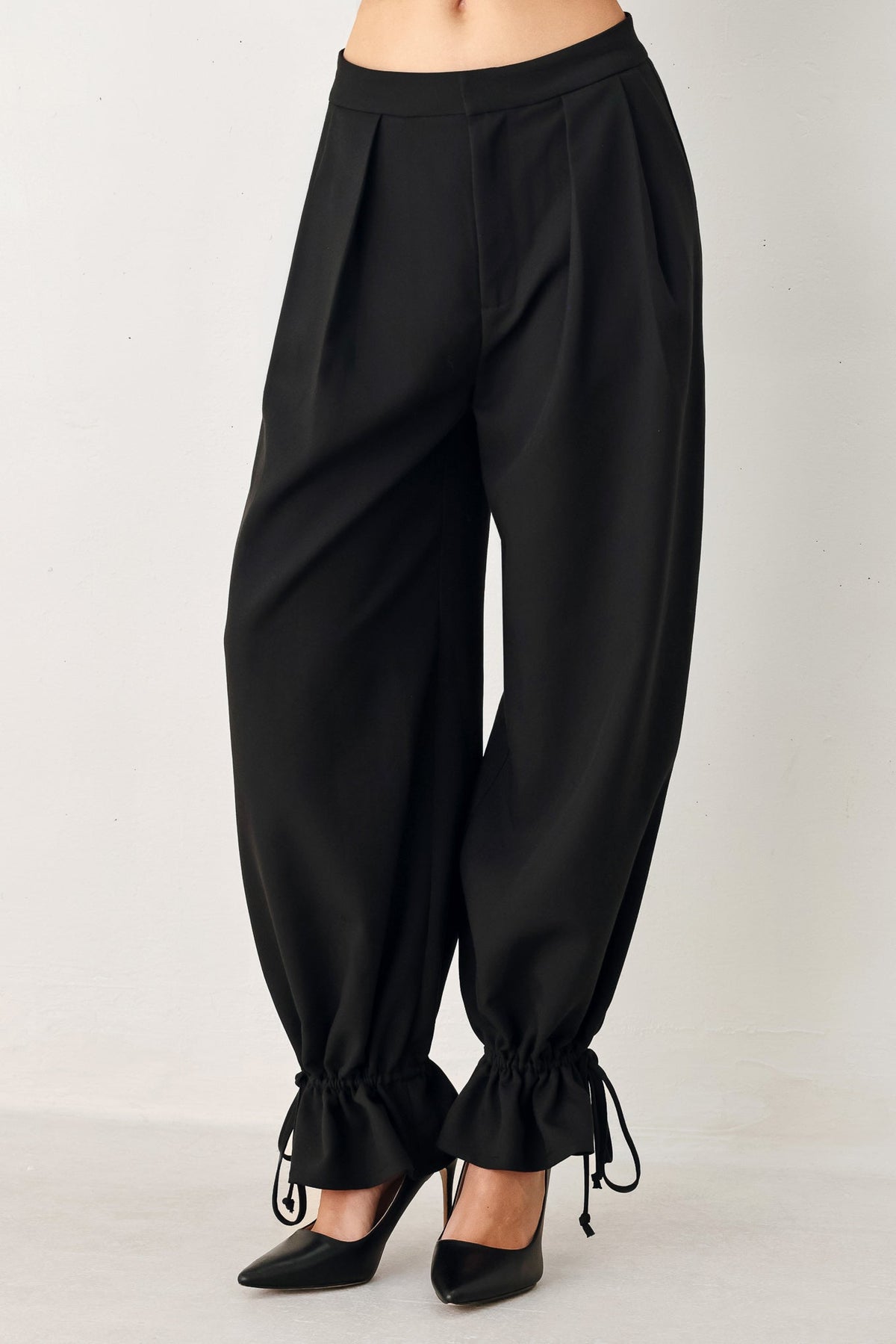 Flying Tomato Noir drawstring woven pants in black, featuring a relaxed fit and adjustable waistband.
