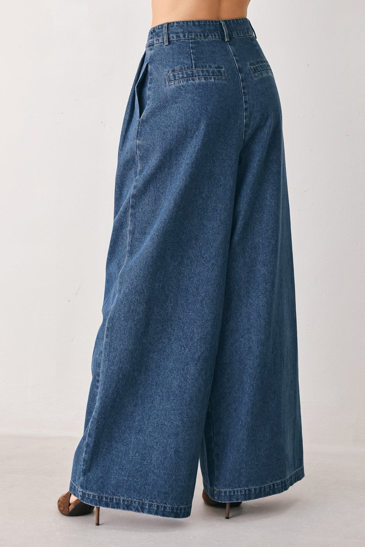 Flying Tomato blue echo pleated denim wide-leg pants with a relaxed fit and medium indigo wash, shown on a model.