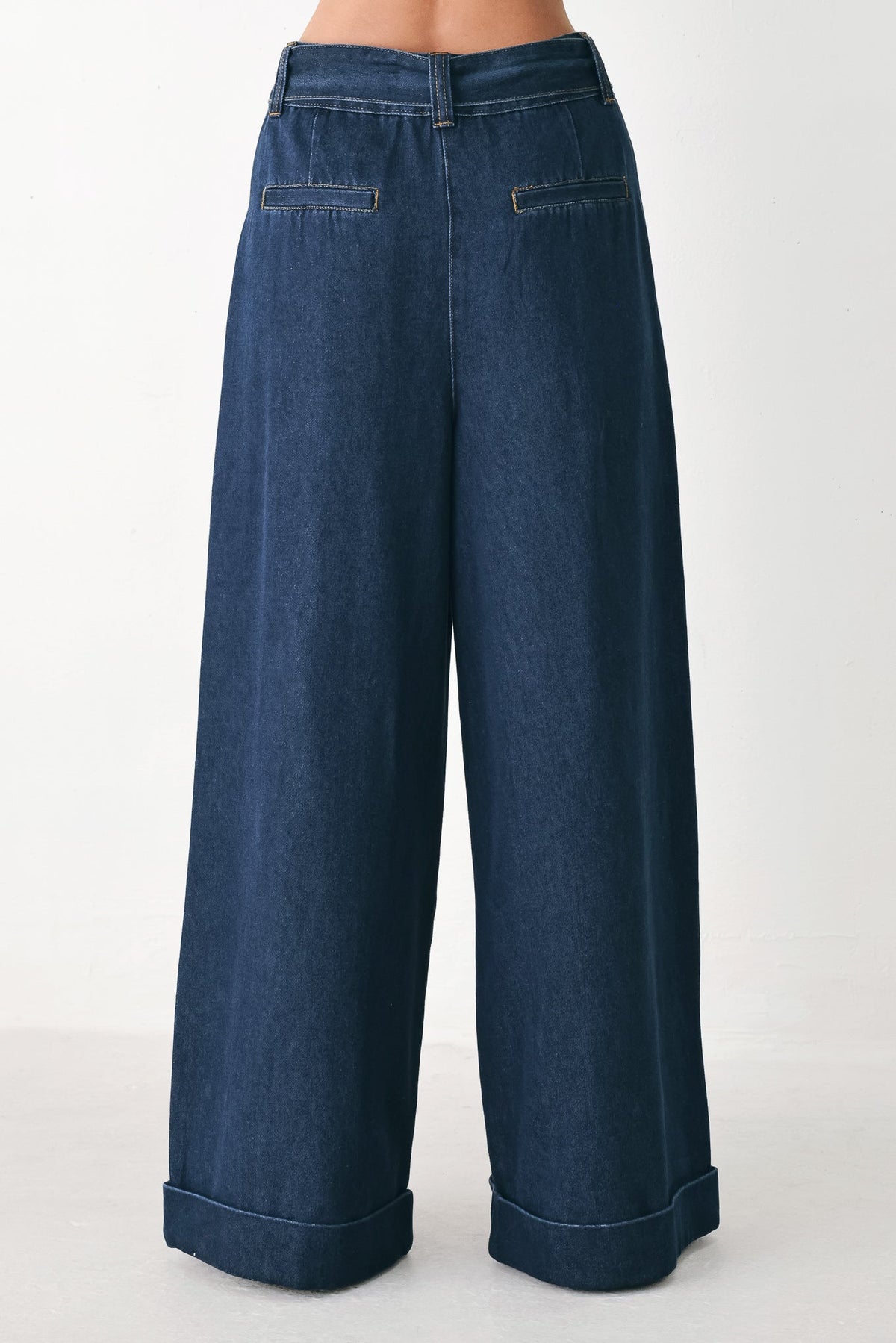 Deep indigo modern muse denim pants by Flying Tomato, showing a close-up of the stylish slim-fit denim fabric and design details.