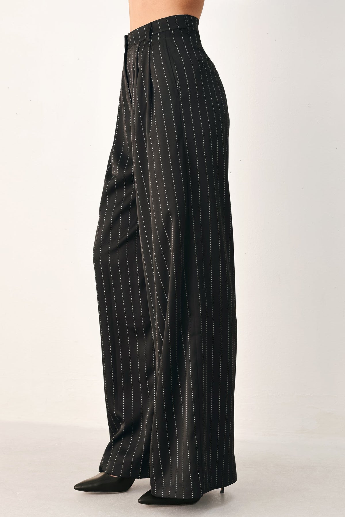 Black Flying Tomato City After Dark striped wide-leg pants with a relaxed fit and bold pattern, displayed on a hanger.