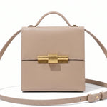 Black leather Nina Cigar Box Bag by thebagicon with a structured rectangular shape and a top handle, detailed with metal hardware.