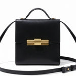 Black leather THE NINA CIGAR BOX BAG by thebagicon with a sleek, structured design and top handle for stylish carry.