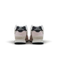 Womens New Balance 574 washed pink sneakers with white soles, casual footwear style, shown from side angle.