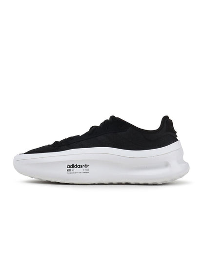 Black and white Adidas men's Adifom Trxn sneakers shown from the side, showcasing sporty footwear design and brand logo.