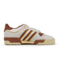 Adidas men's Rivalry Low 86 brown sneakers, low-cut athletic footwear with white accents, on a plain background.