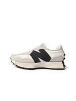 White and black New Balance 327 women's footwear with stylish design and comfortable fit, shown in a close-up image.