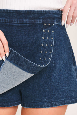 Flying Tomato EDGE LINE denim skort in medium indigo, showing front view with pleats and side pockets.