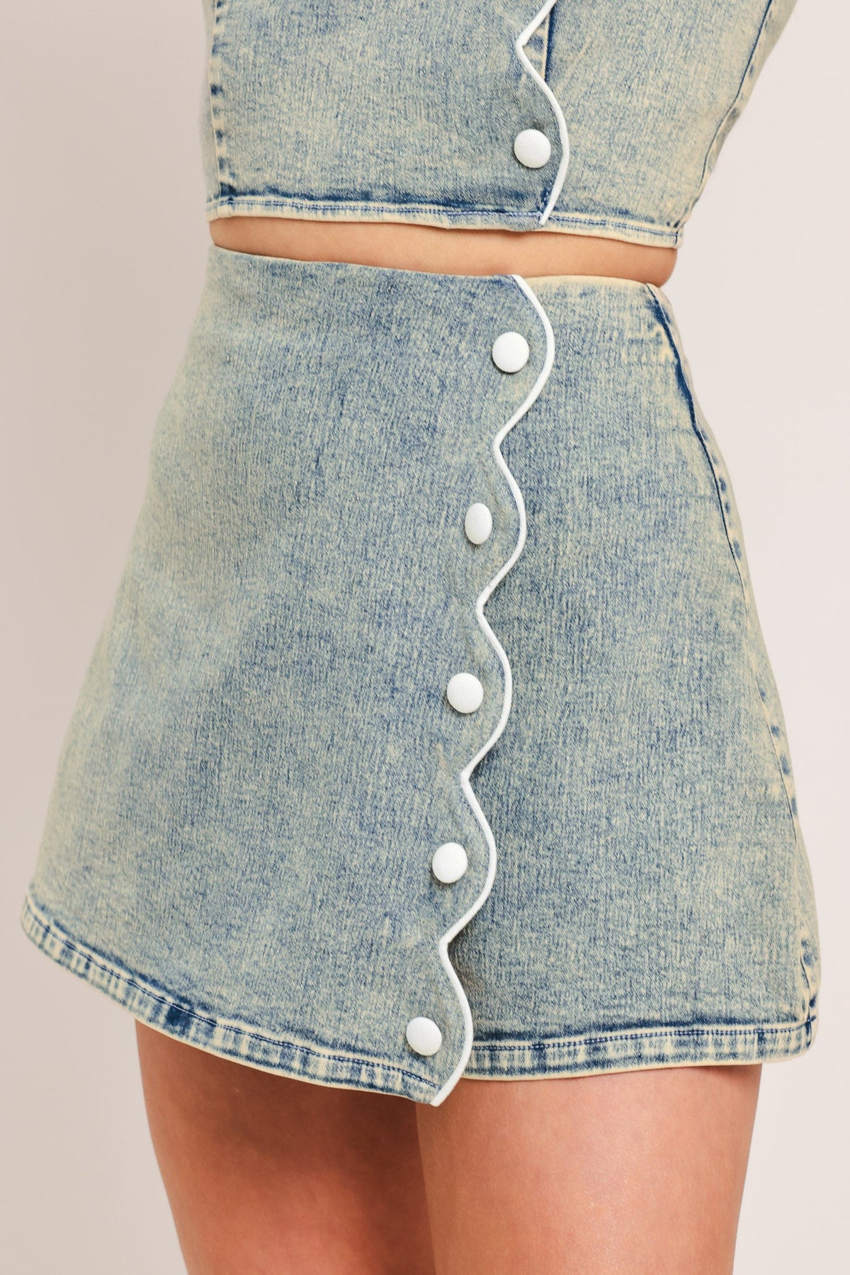 Flying Tomato Sweet Detail Denim Skort showing a stylish blue denim skort with floral embroidery and a front button closure.