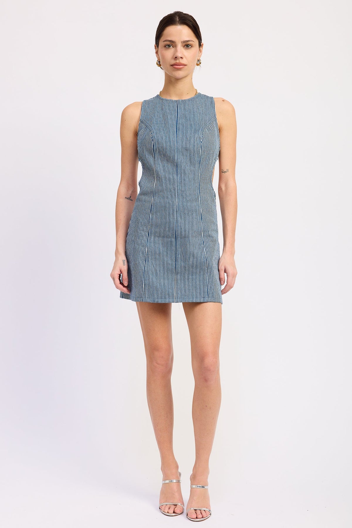 Emory Park Mabel Mini Dress in blue denim, shown on a model, with a fitted silhouette and sleeveless design.