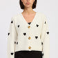 Emory Park Juliette cardigan in ivory and black, lightweight knit with button closure and ribbed cuffs, displayed on a hanger.