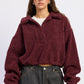 Emory Park Luella sweater in burgundy, soft knit fabric, with a relaxed fit and ribbed cuffs, displayed on a hanger.