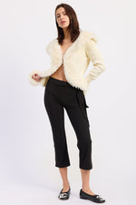 Off-white Emory Park Riva cardigan displayed on a hanger, showcasing its soft knit fabric and classic button-front design.