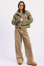 Olive green Dinara puffer jacket by Emory Park, showcasing its quilted design and padded collar for warmth.