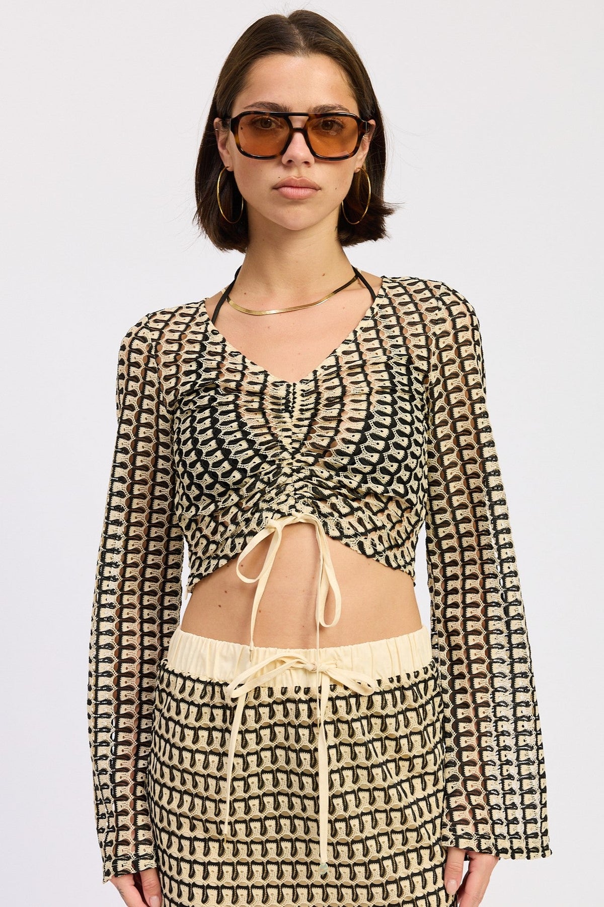 Cream and black Daleyza top by Emory Park, featuring a stylish design, displayed on a neutral background.