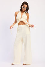 Off-white Jadae halter neck top by Emory Park, featuring a stylish sleeveless design and fitted silhouette.