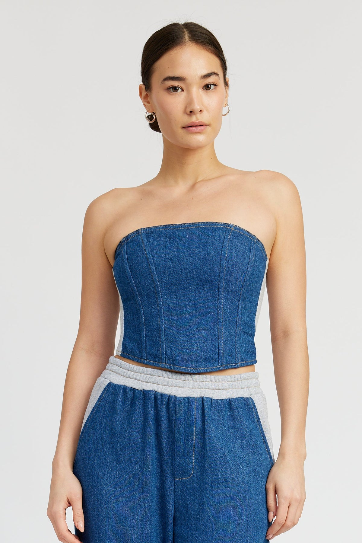 Emory Park Morgan Top in blue denim, casual sleeveless design, displayed on a hanger with a neutral background.