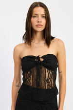 Black Zara tube top by Emory Park shown on a model, featuring a fitted, sleeveless design perfect for casual or stylish wear.
