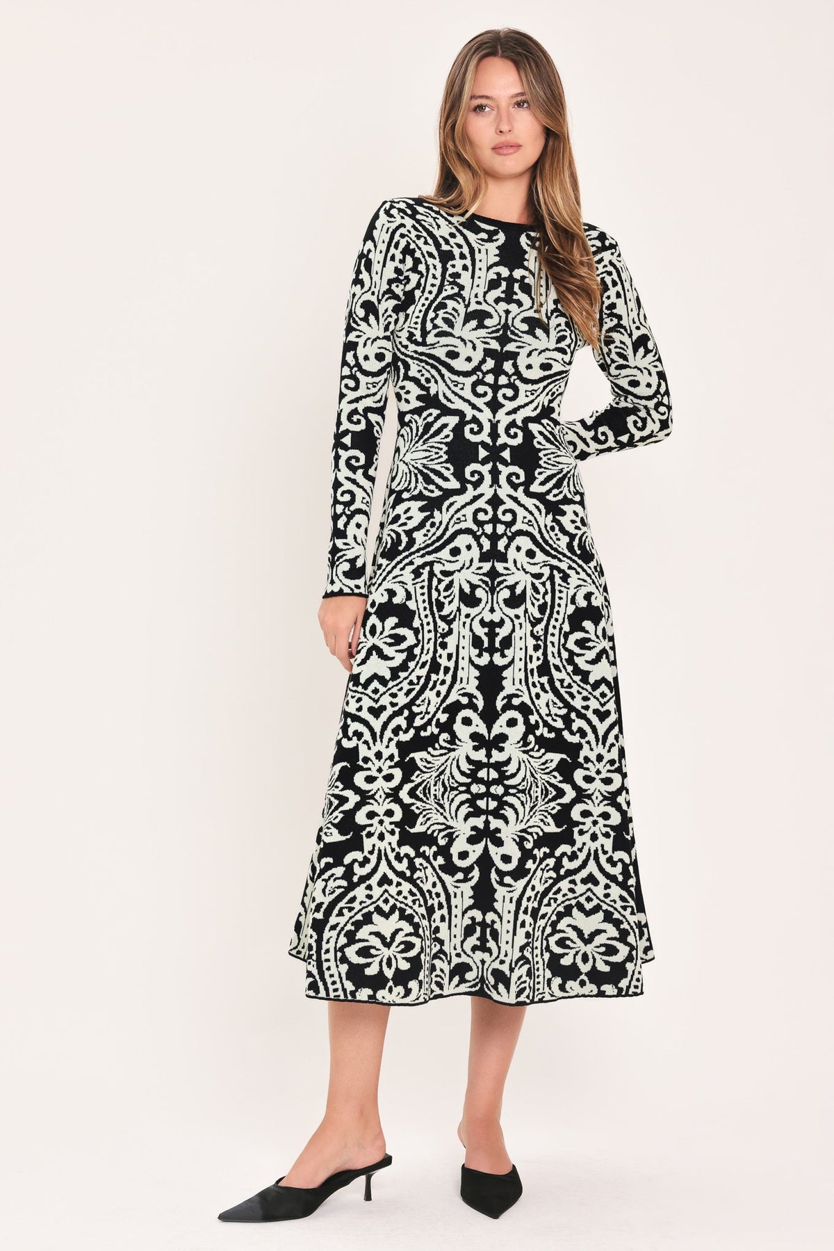 Flying Tomato Midnight Muse black jacquard sweater midi dress displayed on a hanger with detailed floral pattern and long sleeves.