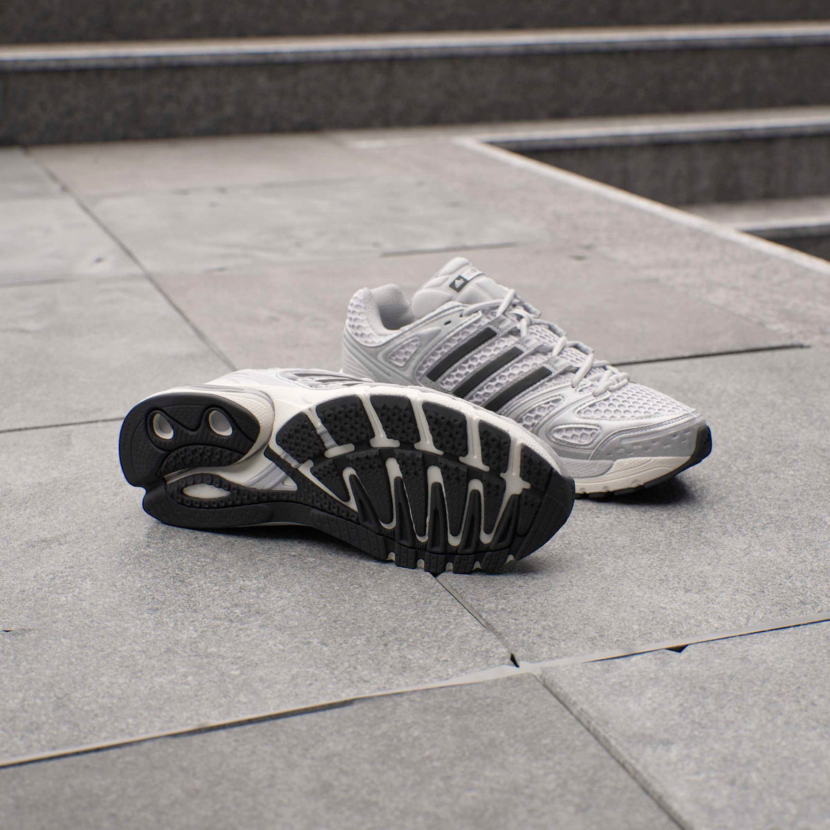 Silver Adidas men's Adistar Control 5 running shoes with breathable mesh and supportive design, ideal for athletic activities.