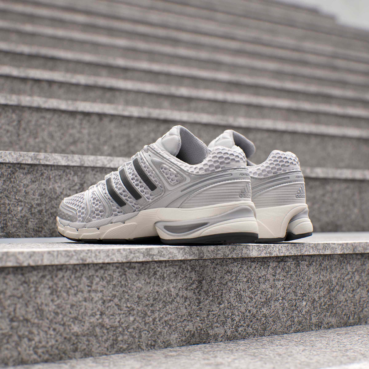 Silver Adidas Mens Adistar Control 5 running shoes with breathable mesh and cushioned sole, displayed on a plain background.